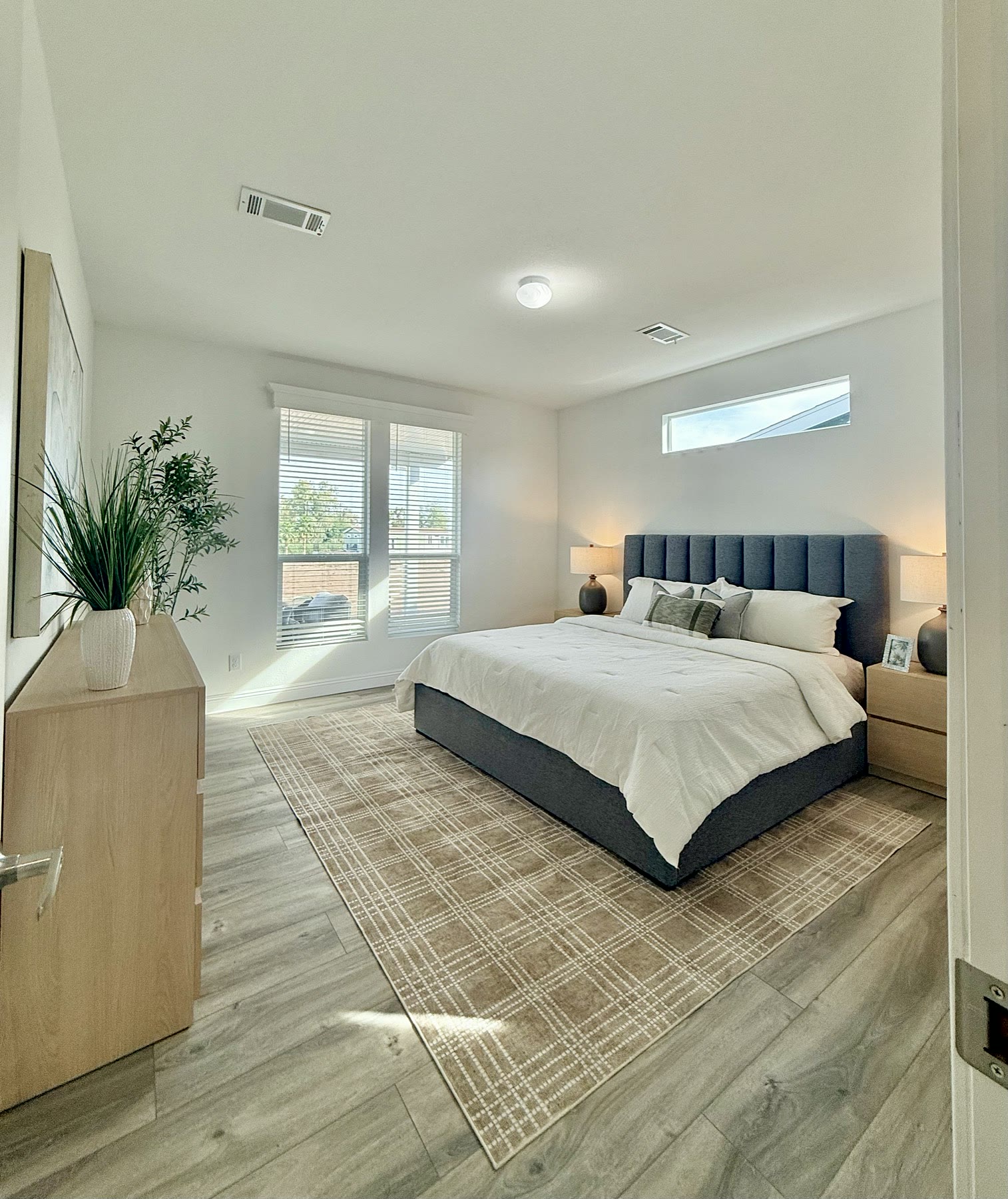 El Mirage bedroom staged with neutral bedding and simple accents