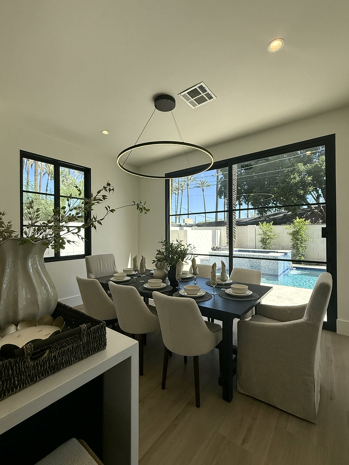 Scottsdale dining room staged with a round table, upholstered chairs, and poolside window views